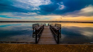 A wooden pier leading into calm water with a clear sky above. - Luxury 6-person villa with swimming pool, sunroof near the beach and golf courses (San Pedro del Pinatar)
