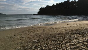 A beach with a sandy shore, calm water, and a forested hill in the background. - LUXURY VILLA WITH PRIVATE POOL ON BEAUTIFUL AND ACCESSIBLE LUSTICA PENINSULA (Ðuraševici)