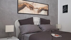 A modern bedroom with a large bed, two bedside tables, and a framed artwork above the bed. - Luxury apartment 200 meters from St. Peter's basilica, in the heart of Rome (Roma)