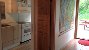 A kitchen with wooden cabinets, a stove, and a map on the wall.