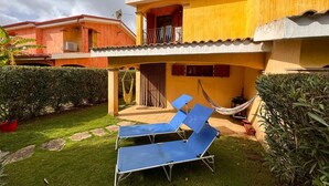 A yellow building with a balcony and a hammock.