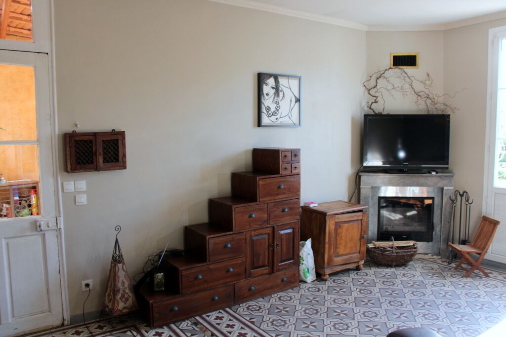 Una sala de estar con chimenea, televisor y una escalera con armarios.