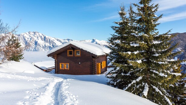 A wooden cabin with a snow-covered roof, surrounded by snow and a mountain backdrop. - Chalet l'Ange - La Tzoumaz, 4 Vallees (La Tzoumaz)