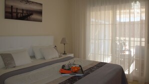 A neatly made bed with a tray of oranges and a cup, a lamp, and a painting on the wall. - Estepona, cozy 2 bedrooms apartment close to the beach and marina (Estepona)