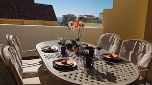 A round dining table with six chairs, set for a meal with plates, cutlery, and wine glasses. A vase with flowers is placed in the center. - Estepona, cozy 2 bedrooms apartment close to the beach and marina (Estepona)