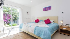 Un dormitorio moderno con una cama, mesita de noche y vistas al exterior.