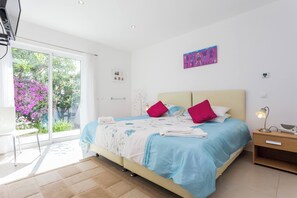 A modern bedroom with a bed, bedside table, and a view of the outdoors. - CoolHouses Algarve Lagos | Casa Redonda (Lagos)