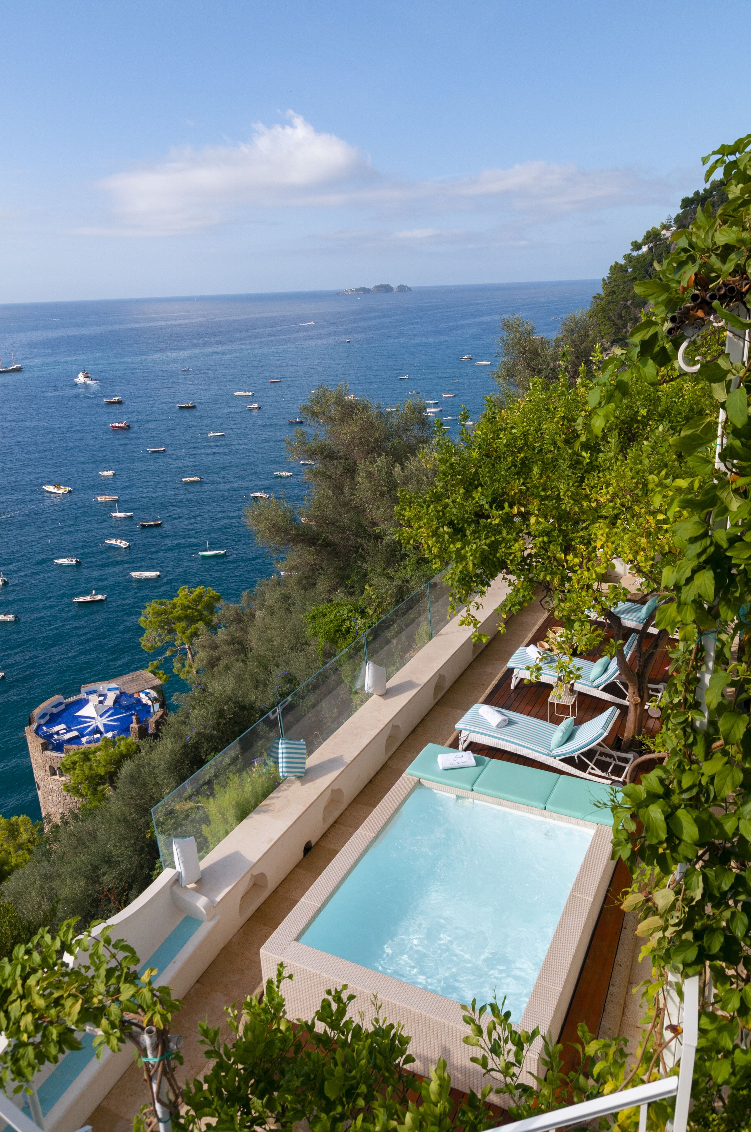 A rooftop pool with a view of the sea and boats.
