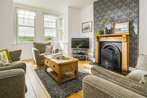 A living room with a fireplace, a television, and a sofa.