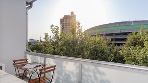 Ein Balkon mit Tisch und Stühlen, mit Blick auf eine Parkgarage und Gebäude.
