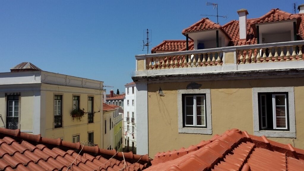 A row of buildings with red-tiled roofs and balconies.