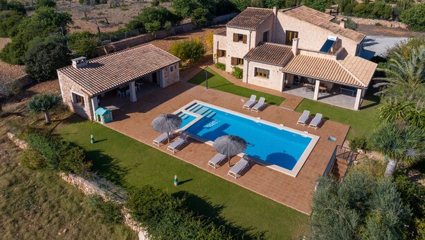 Una villa con piscina, mobiliario exterior y vistas del paisaje circundante.