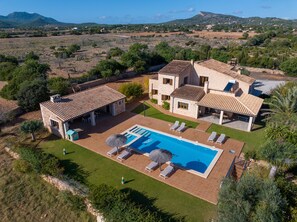 Una villa con piscina, mobiliario exterior y vistas del paisaje circundante.