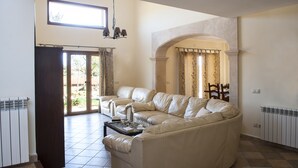 Una sala de estar con un sofá seccional color beige, una mesa de centro y una araña.