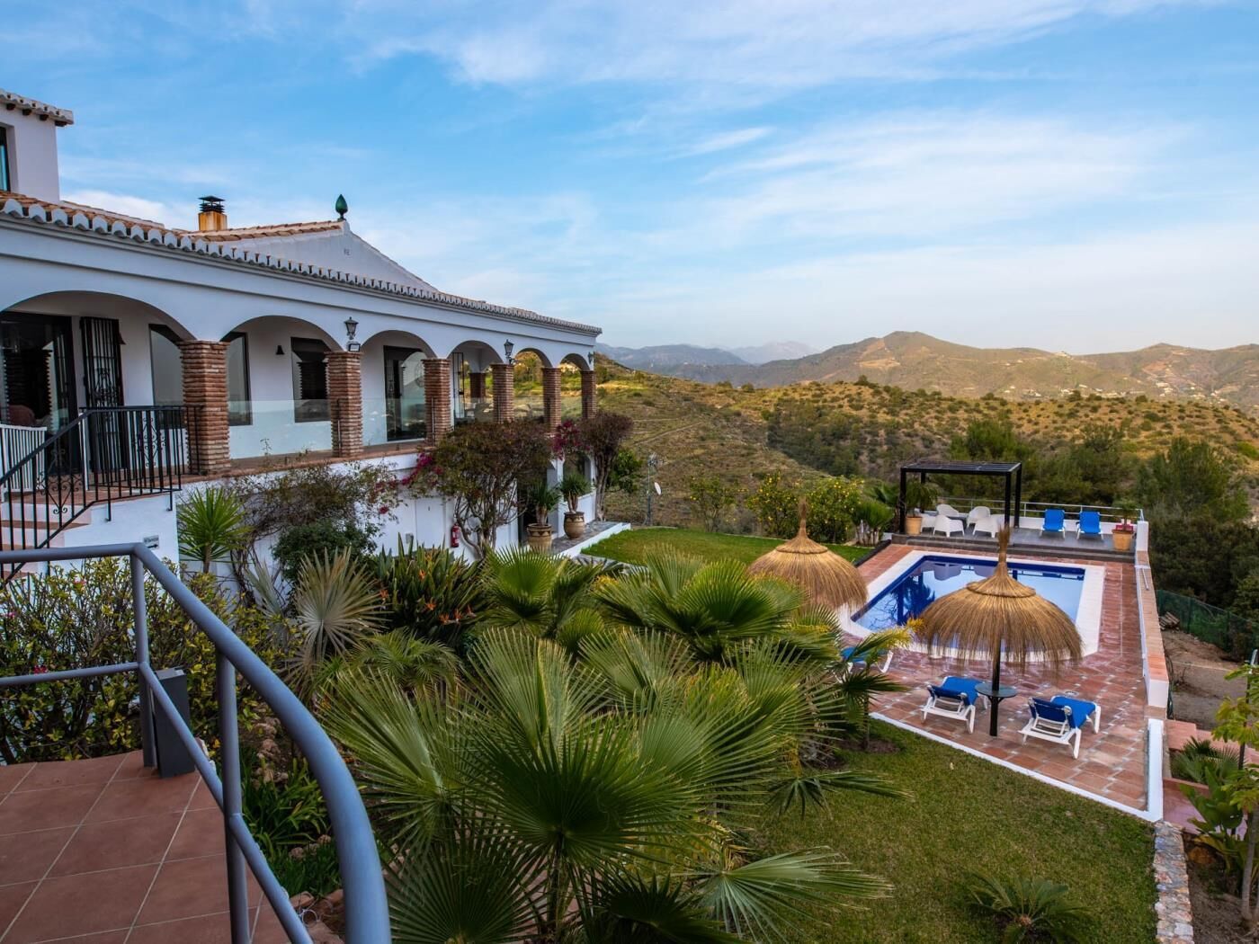 Une villa avec piscine, un espace salon extérieur et une vue sur les montagnes.