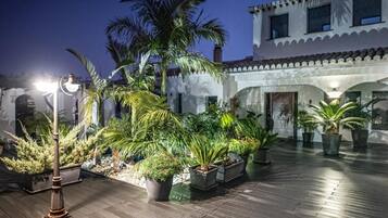 An outdoor courtyard with potted plants and a street lamp.