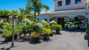 A courtyard with potted plants, a lamp post, and a building with a tiled roof and arches. - Luxury Villa with private pool La Herradura (La Herradura)
