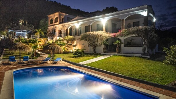 A swimming pool with lounge chairs, a well-maintained lawn, and a building with arched windows and a tiled roof. - Luxury Villa with private pool La Herradura (La Herradura)