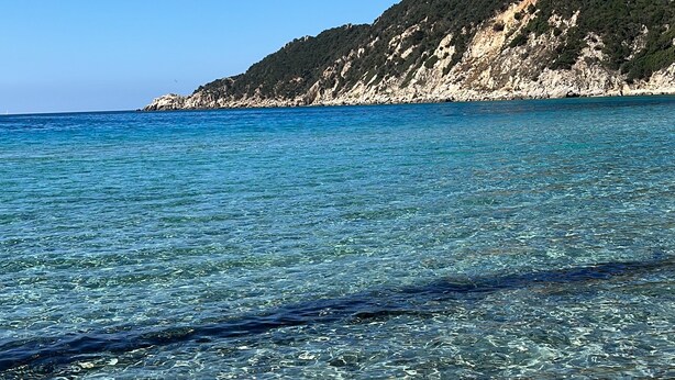 A clear coastal view with a rocky shoreline and a hill in the background. - VILLA DANTE south Sardinia Between countryside and sea (Castiadas)