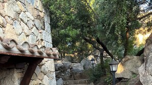 A stone staircase leading up a hill, surrounded by large rocks and trees. - VILLA DANTE south Sardinia Between countryside and sea (Castiadas)