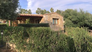 A stone building with a small window, surrounded by dense greenery and trees. - VILLA DANTE south Sardinia Between countryside and sea (Castiadas)