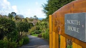 Een houten poort met een bord waarop 'NORTH SHORE' staat.