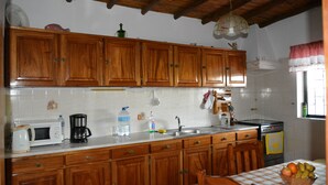 A kitchen with wooden cabinets, a microwave, a coffee maker, and a sink. - Villa with Private Swimming Pool / WI-Fi / Pet friendly (8700-176 Olhao)
