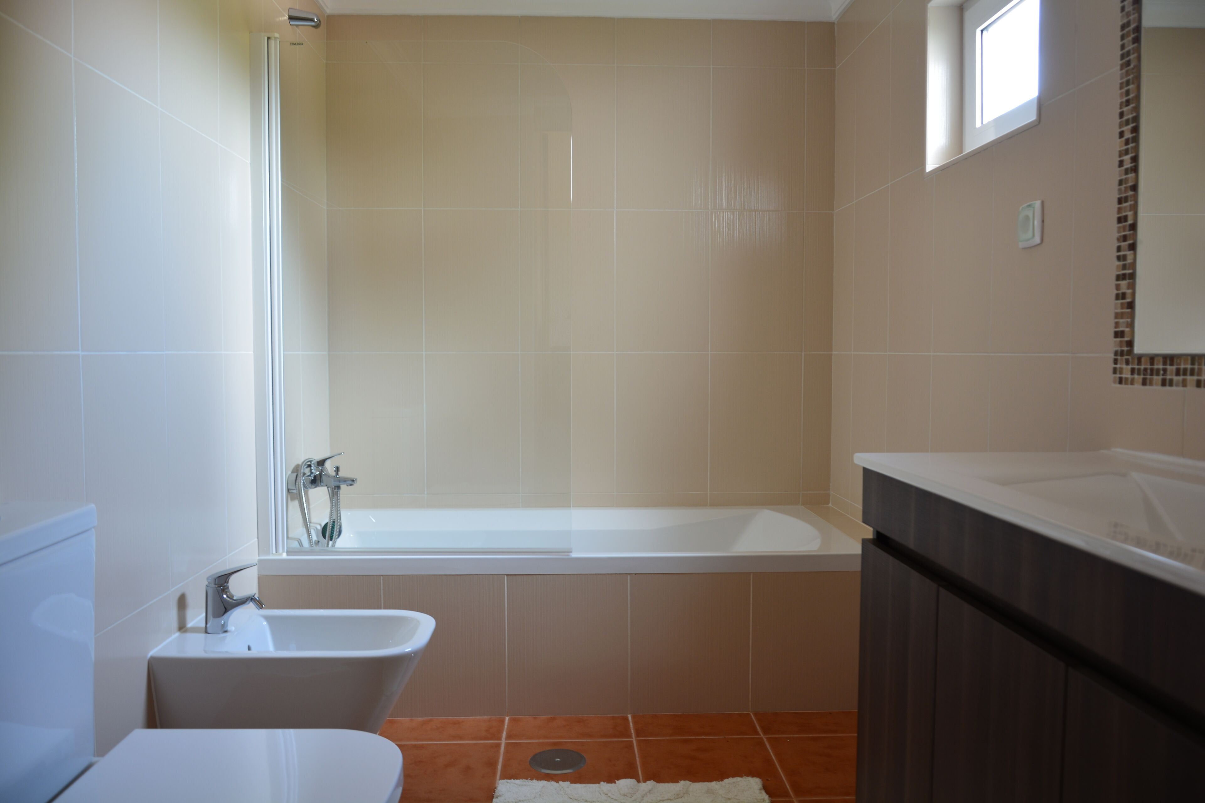 Et badeværelse med badekar, toilet og vask.