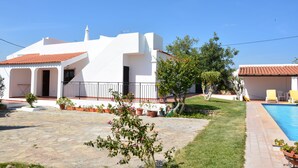 A white villa with a tiled roof, a swimming pool, and a stone courtyard. - Villa with Private Swimming Pool / WI-Fi / Pet friendly (8700-176 Olhao)