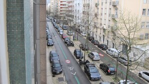 Katunäkymä, jossa on parkkeerattuja autoja ja rakennuksia.