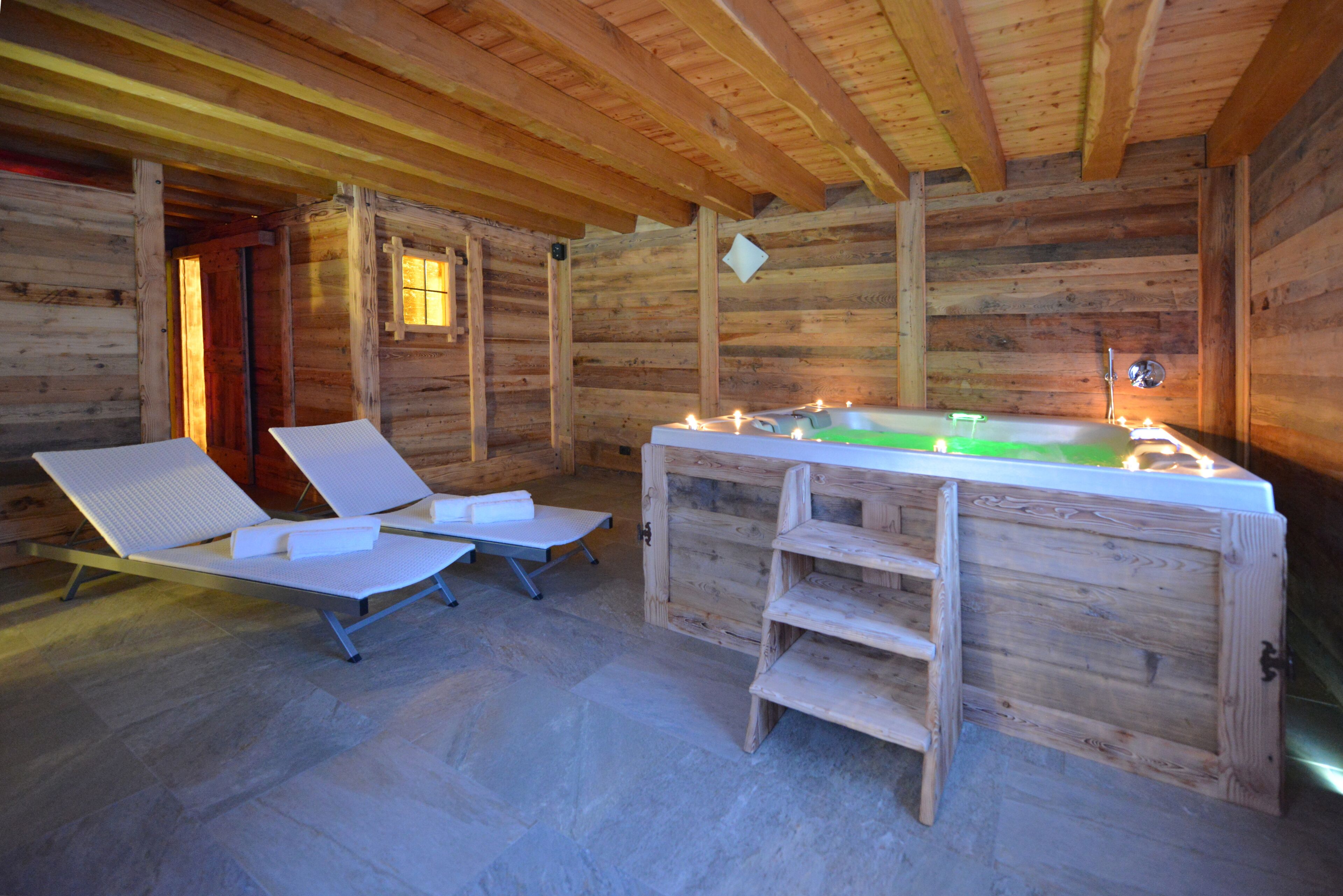 A wooden cabin interior with a sauna, two reclining chairs, and a wooden bench.