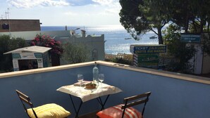 Un espace extérieur aménagé avec une table et des chaises, donnant sur une étendue d’eau.