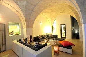 A spacious living area with a high arched ceiling, a sofa set, a coffee table, and a decorative lantern. - Stunning Masseria With Every Comfort, 5 Mins From Ostuni, 2 pools, air-con (Ostuni)