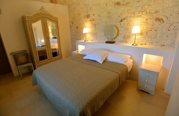 Un dormitorio con una cama grande, un aparador y dos lámparas de noche.