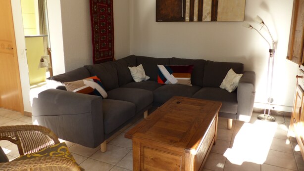A living room with a sectional sofa, a wooden coffee table, and a floor lamp. - Holiday house at 800m from the beach in De Haan (De Haan)