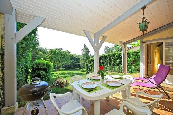 An outdoor patio with a table set for dining, surrounded by chairs, and a barbecue grill. - 15 mins from Sarlat and caves comfortable cottage with swimming pool, (Tamniès)