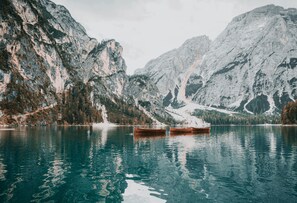 Un lac paisible où l’on peut faire du bateau, entouré de montagnes escarpées.