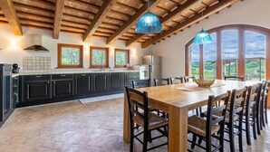 A kitchen with dark cabinets, a wooden ceiling, and a dining area with a table and chairs. - Villa Lucia with pool in the Marche region, elegant and spacious, a few kilometers from the Adriatic (Barchi)