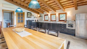 A spacious kitchen with wooden beams, a large island, and modern appliances. - Villa Lucia with pool in the Marche region, elegant and spacious, a few kilometers from the Adriatic (Barchi)