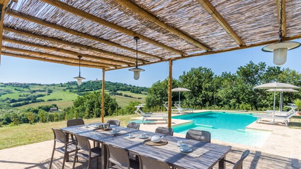 A covered outdoor area with a pool, dining table, and chairs. - Villa Lucia with pool in the Marche region, elegant and spacious, a few kilometers from the Adriatic (Barchi)