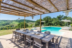 A covered outdoor area with a pool, dining table, and chairs. - Villa Lucia by Anita Villas (Barchi)