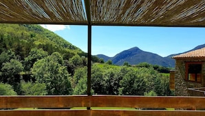 A wooden deck with a view of a mountainous landscape. - Rural house in an impressive natural setting! Up to 10 people (Montagut I Oix)