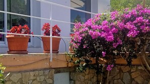 A modern building with a balcony, potted plants, and a stone wall. - Loft in Aiguablava beach. Costa Brava. With private garden and sea views. (Begur)