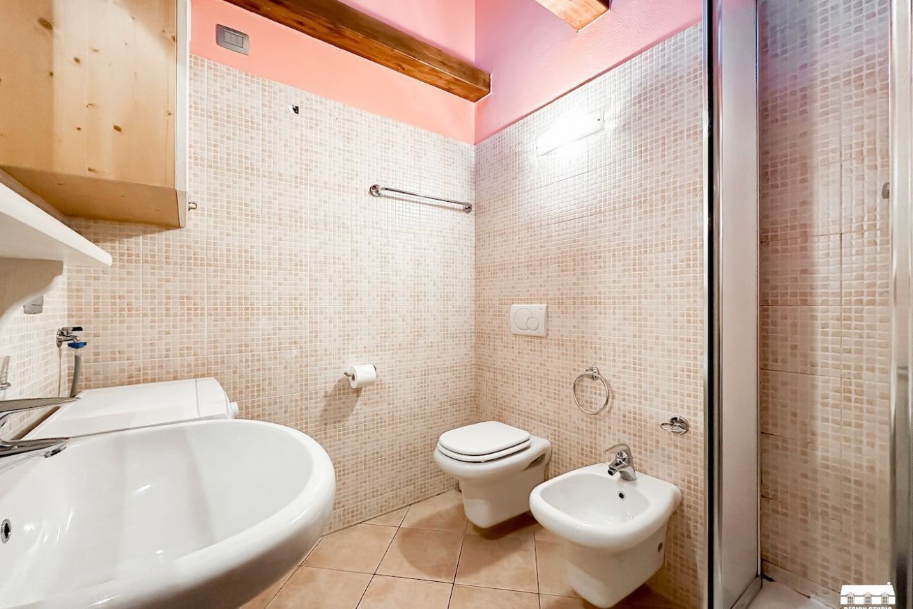Une salle de bain comprenant un grand lavabo, des toilettes, un bidet et un espace douche.