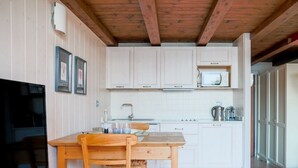 Une cuisine avec des meubles en bois, un four à micro-ondes et un évier.