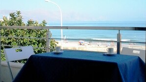 Un tavolo con una tovaglia blu su un balcone vista spiaggia.