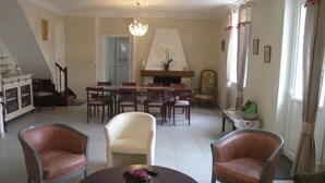 Un salón amplio con chimenea, comedor y escalera.