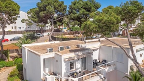 Un bâtiment moderne doté d’un toit plat, d’un espace extérieur aménagé pour s’asseoir et de climatiseurs.