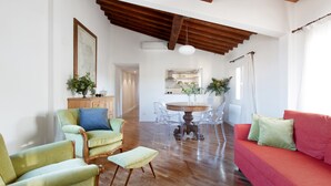 A spacious living area with a wooden ceiling, a round dining table with chairs, a red sofa, and a green armchair. - Apartment The basket of the Angels, Florence amazing views (Firenze)