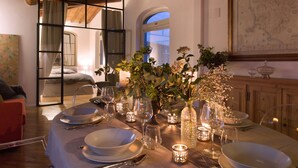 A dining table set for a meal with candles, glassware, and a vase of flowers. - Apartment The basket of the Angels, Florence amazing views (Firenze)